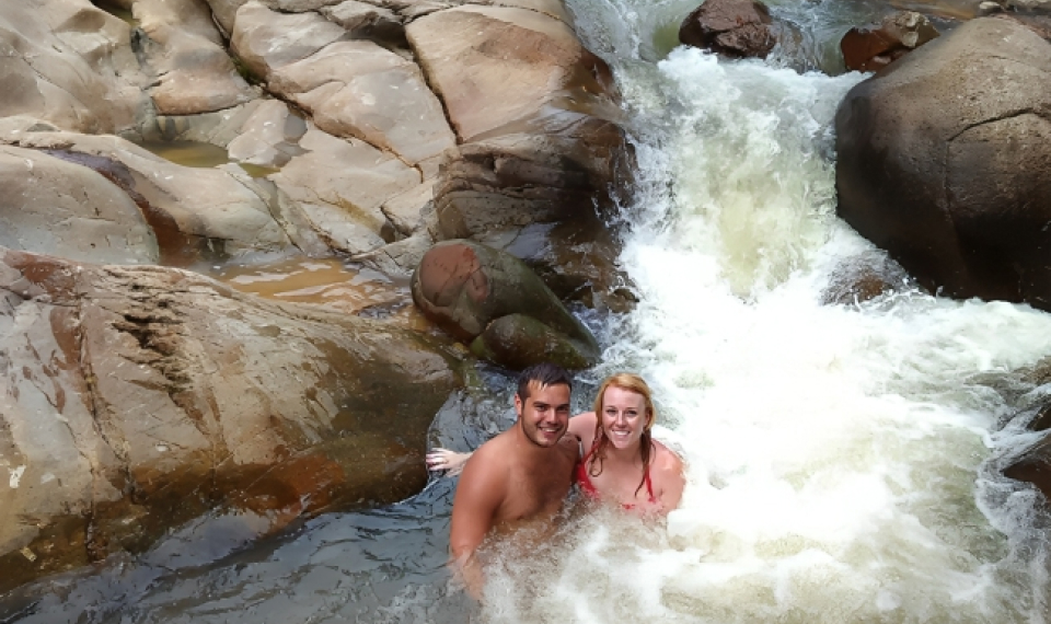 Travelers in swimwear enjoying a refreshing dip at a waterfall, a scenic highlight of their 2-hour Koh Samui ATV tour