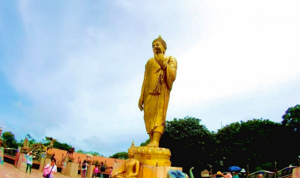 Visitors marveling at the impressive golden Buddha at Wat Pra Putta Teepangkorn during a spiritual Samui tour